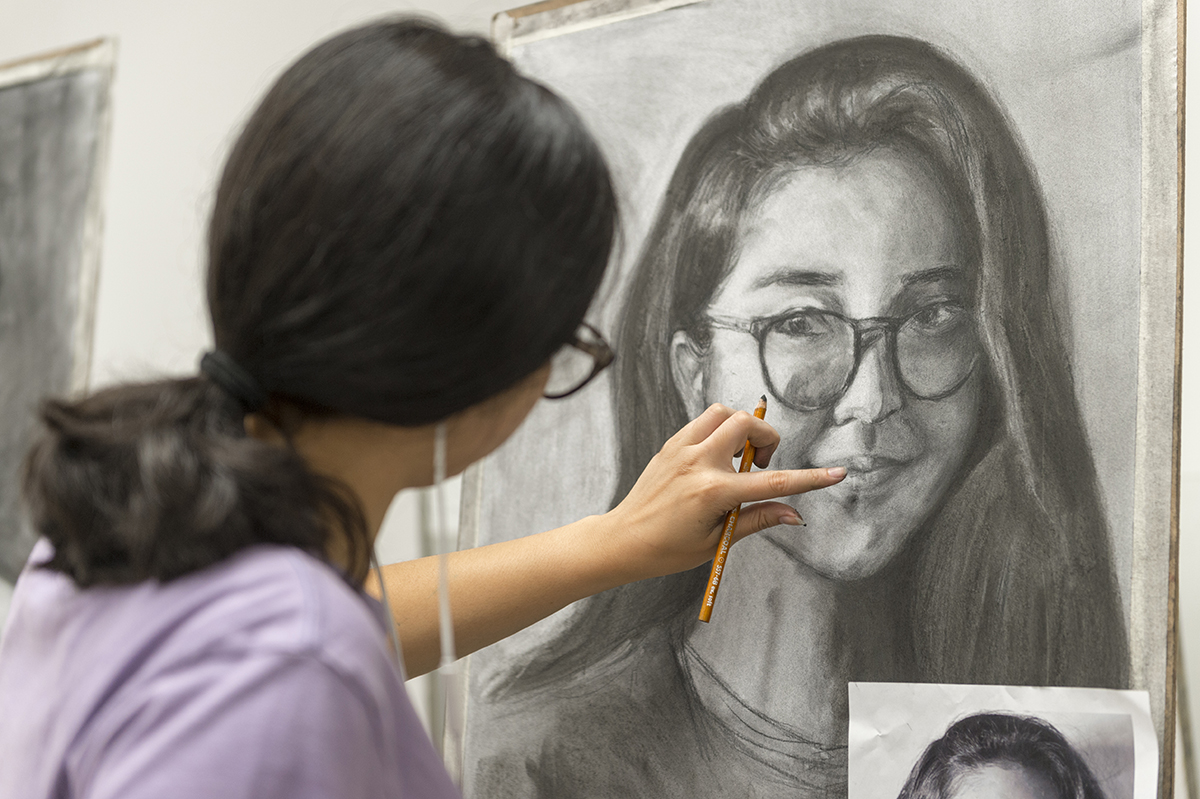 A student working on the self-portrait assignment