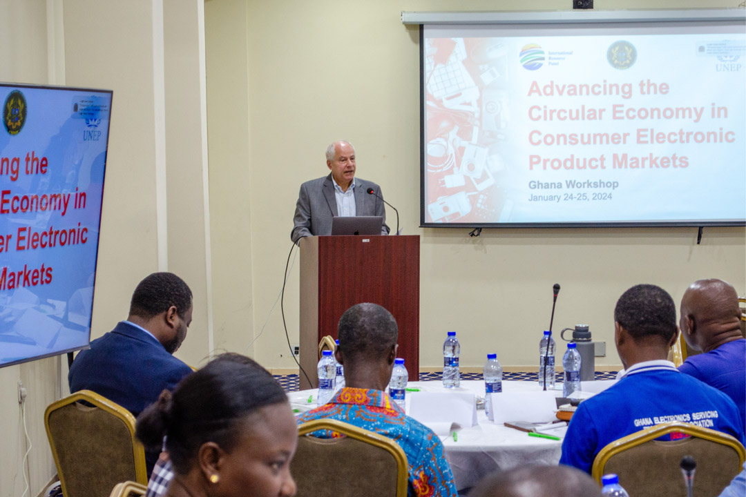 A man speaks at a podium in a conference room.