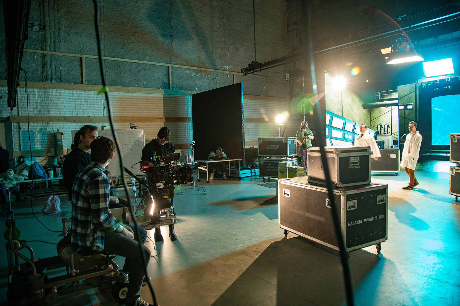 A group of students work on operating camera equipment on a soundstage.