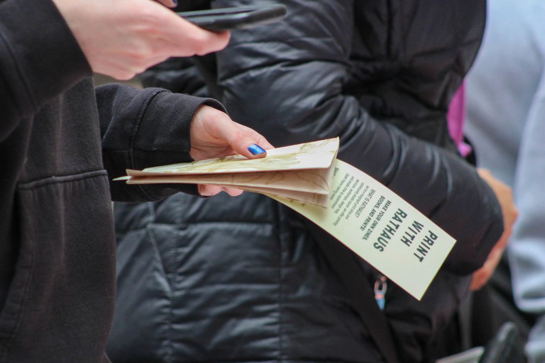 a students hand holding a zine