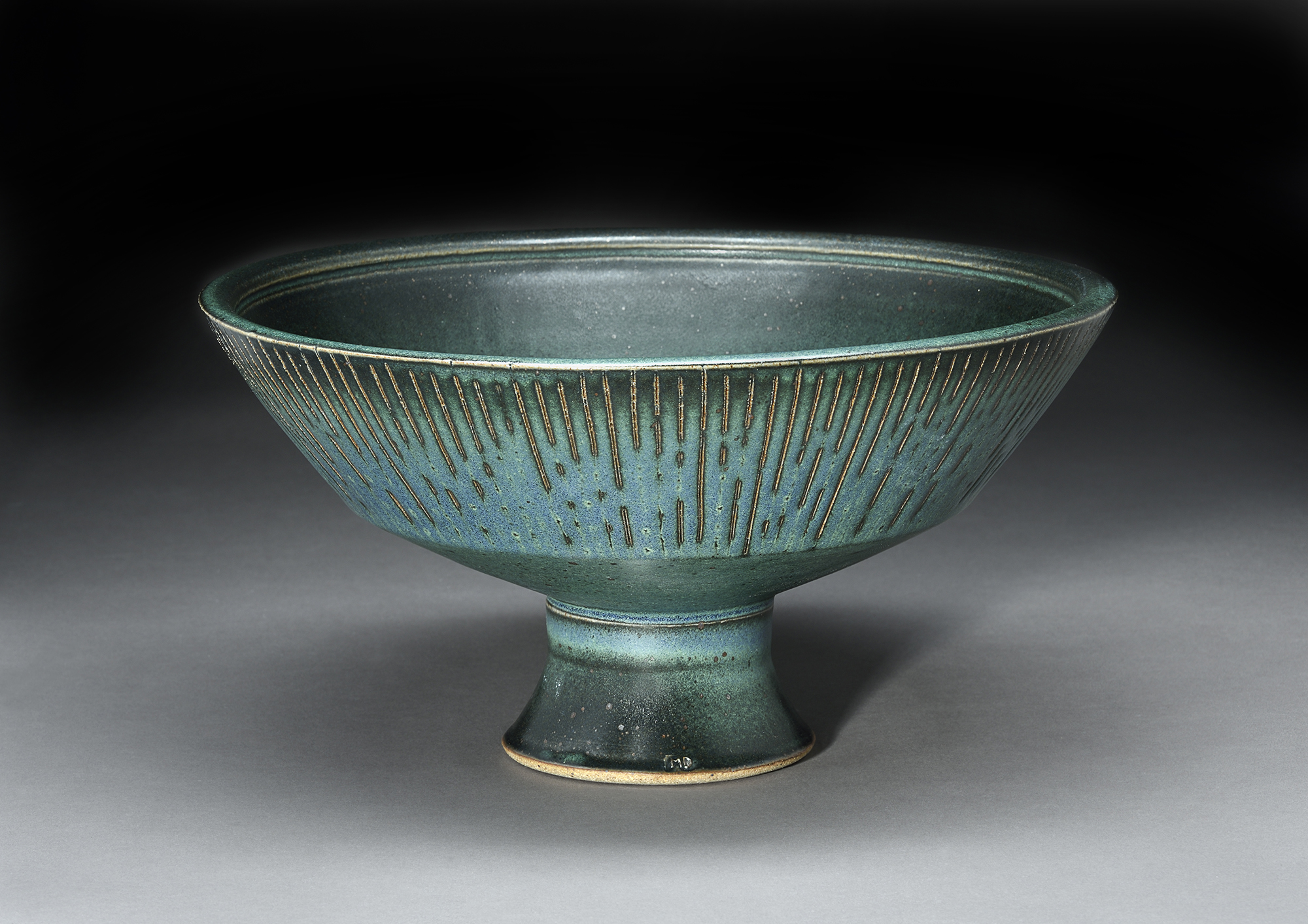 A green and black vessel created by Marian Draper.