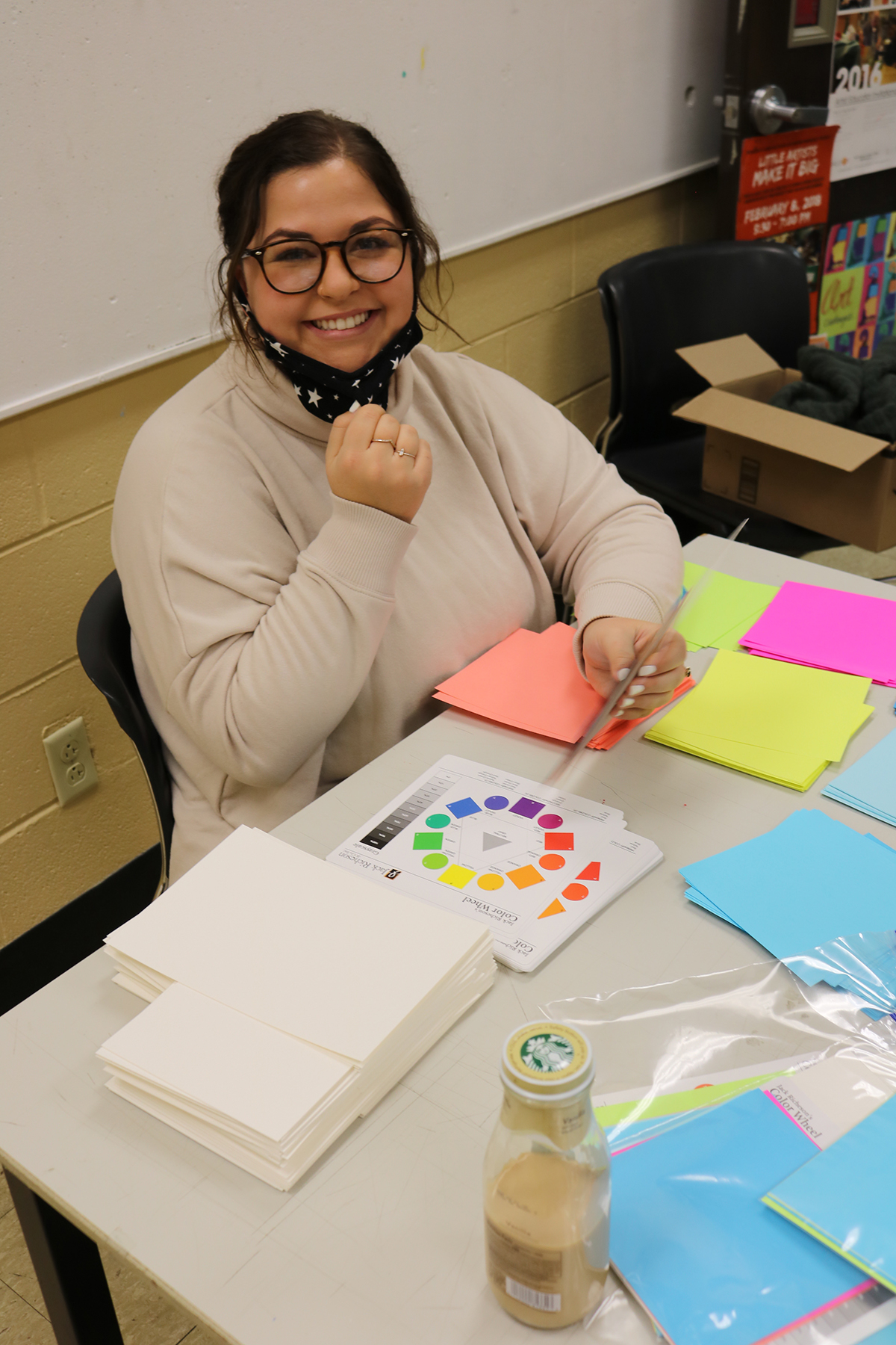 A student puts together supplies for the art kits.