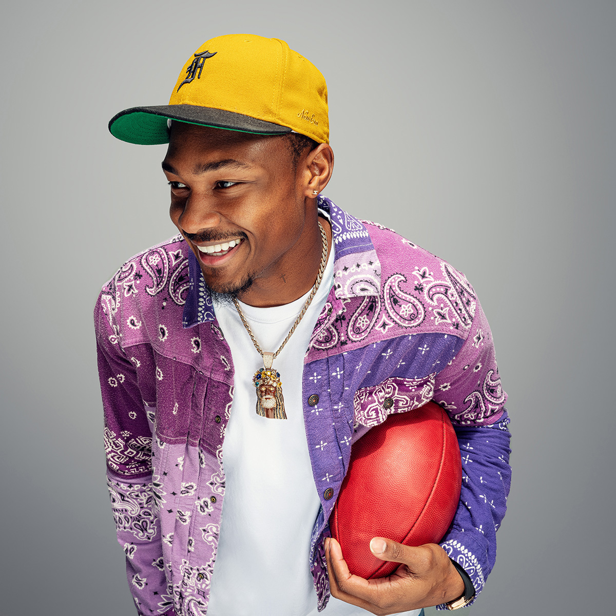 Stefon Diggs holding a football and smiling.