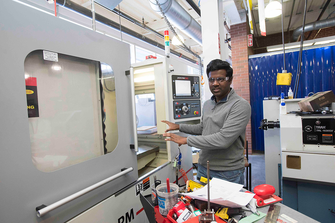 student working with large industrial machine.