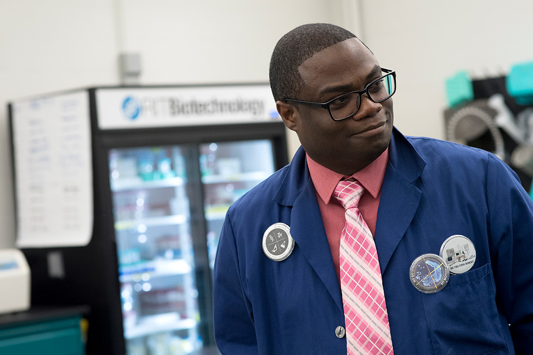 Professor wearing glasses and blue lab coat.