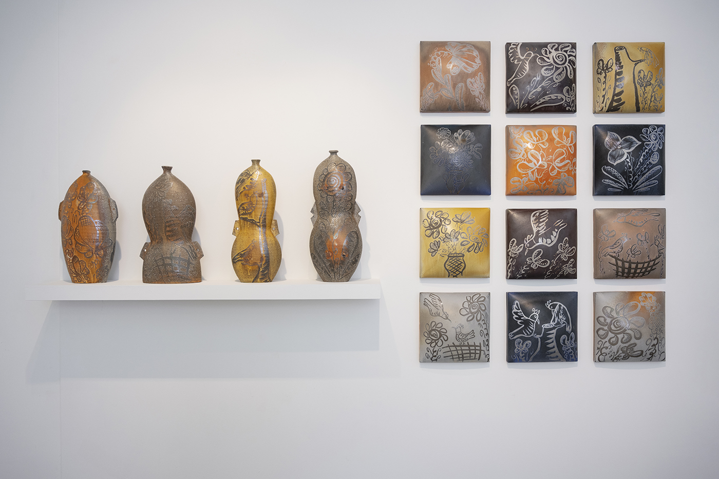 Vessels and platters on gallery pedestals and walls.