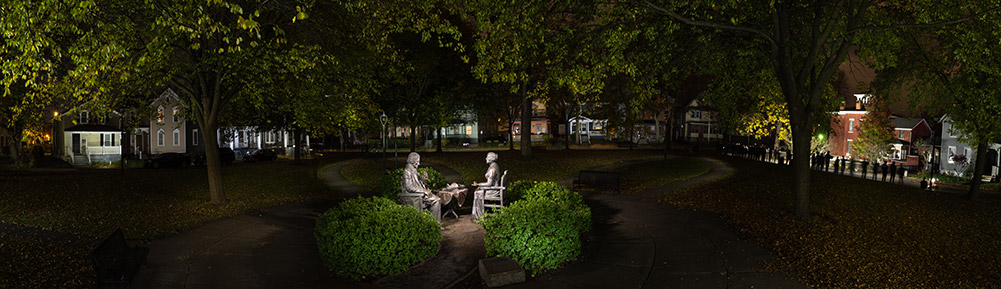 statues of Frederick Douglass and Susan B. Anthony having tea in a park.