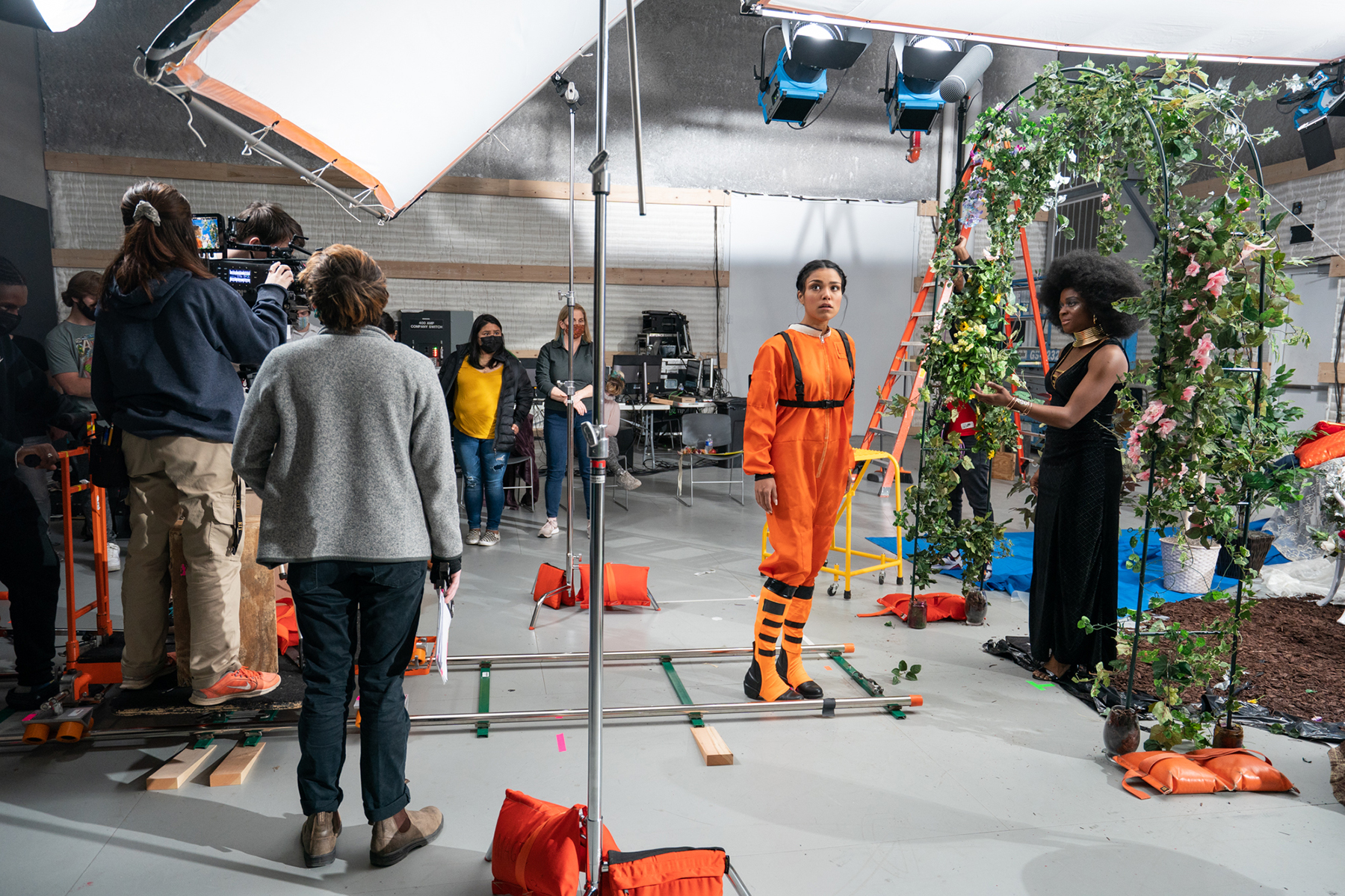 A film crew focuses on an actor in a space suit.