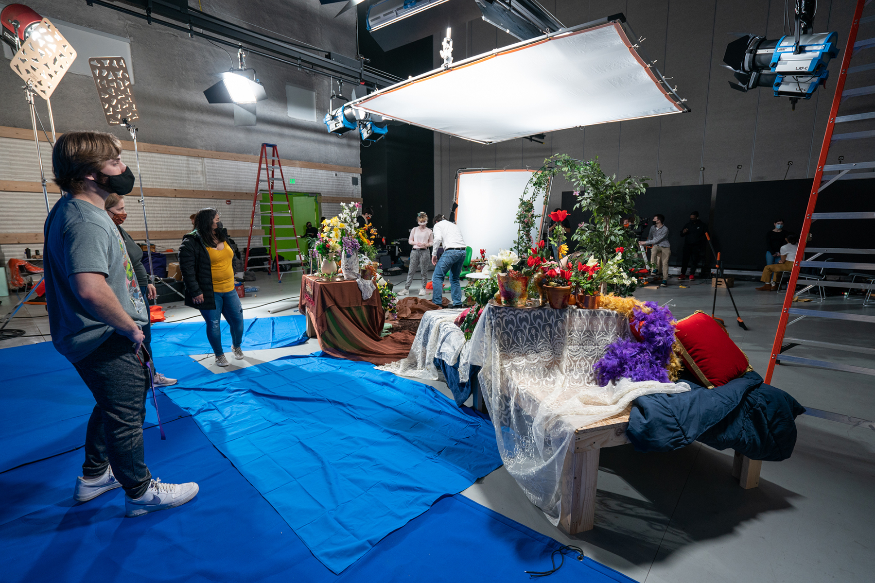 A student film crew surveys the set props.