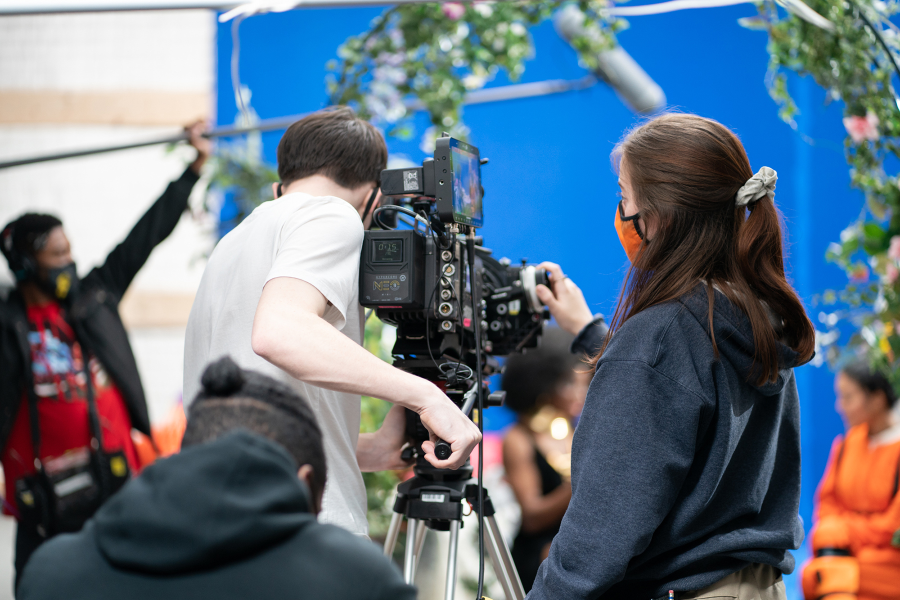 A back-view of two students operating a camera