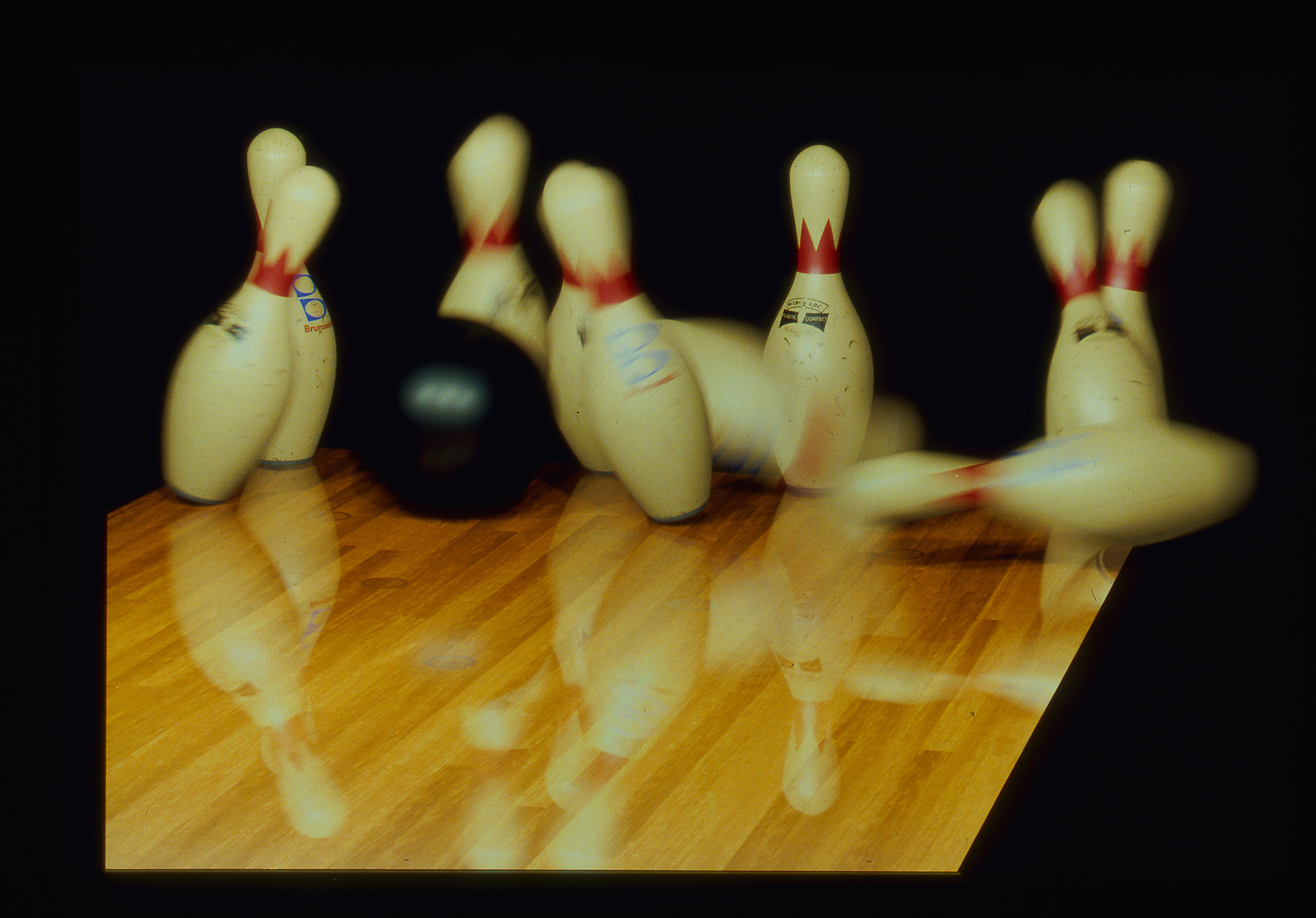 A bowling ball takes out a set of pins.