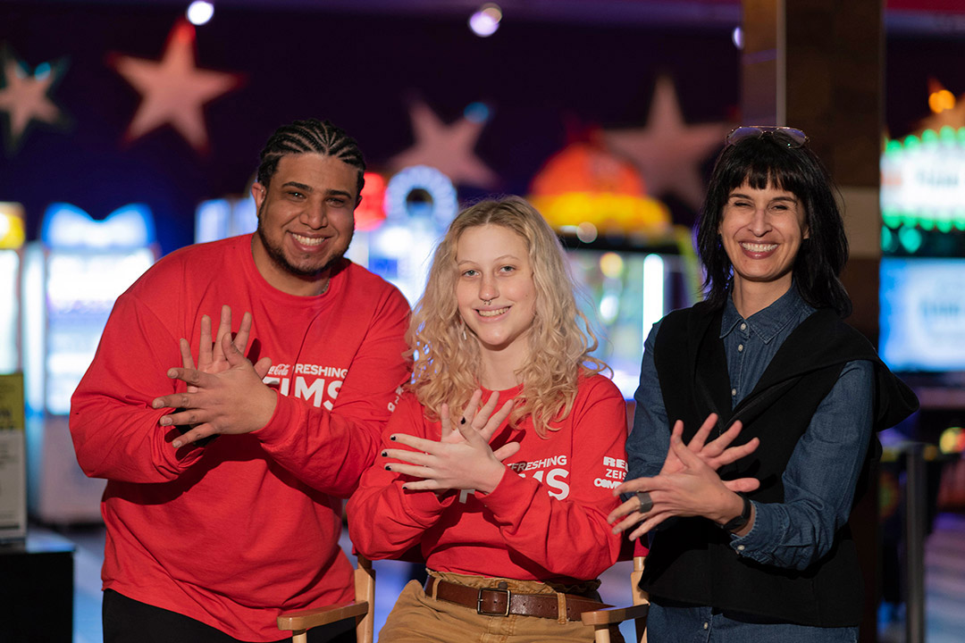 three people signing cheese in sign language.