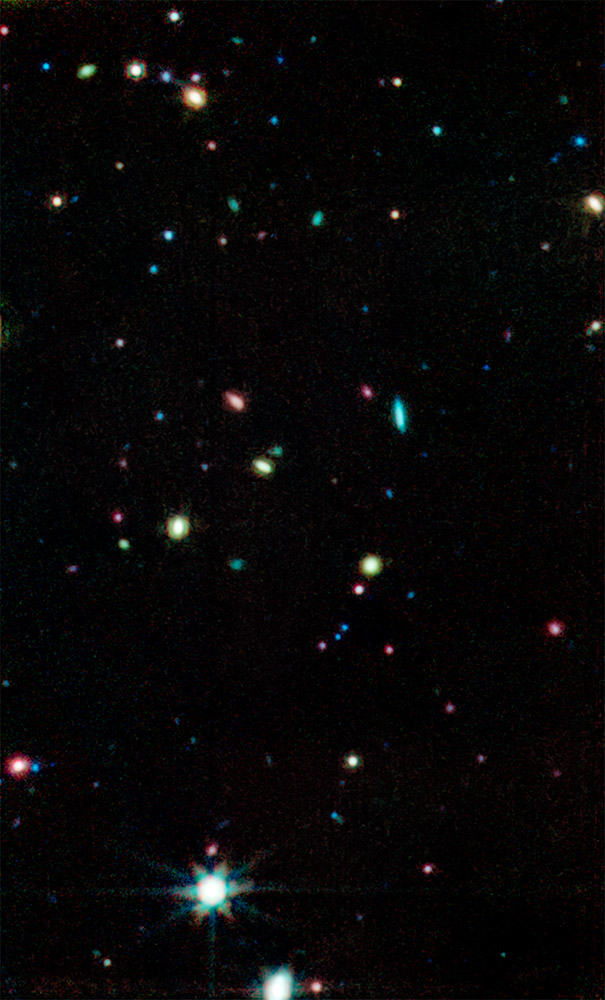 image from a space telescope showing specks and blobs of differing sizes and colors.