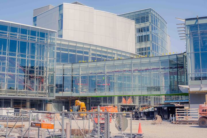 a multiple-story glass building and bridge under construction.