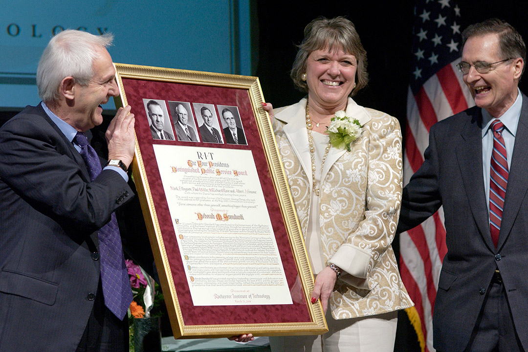 woman and man holding large framed award