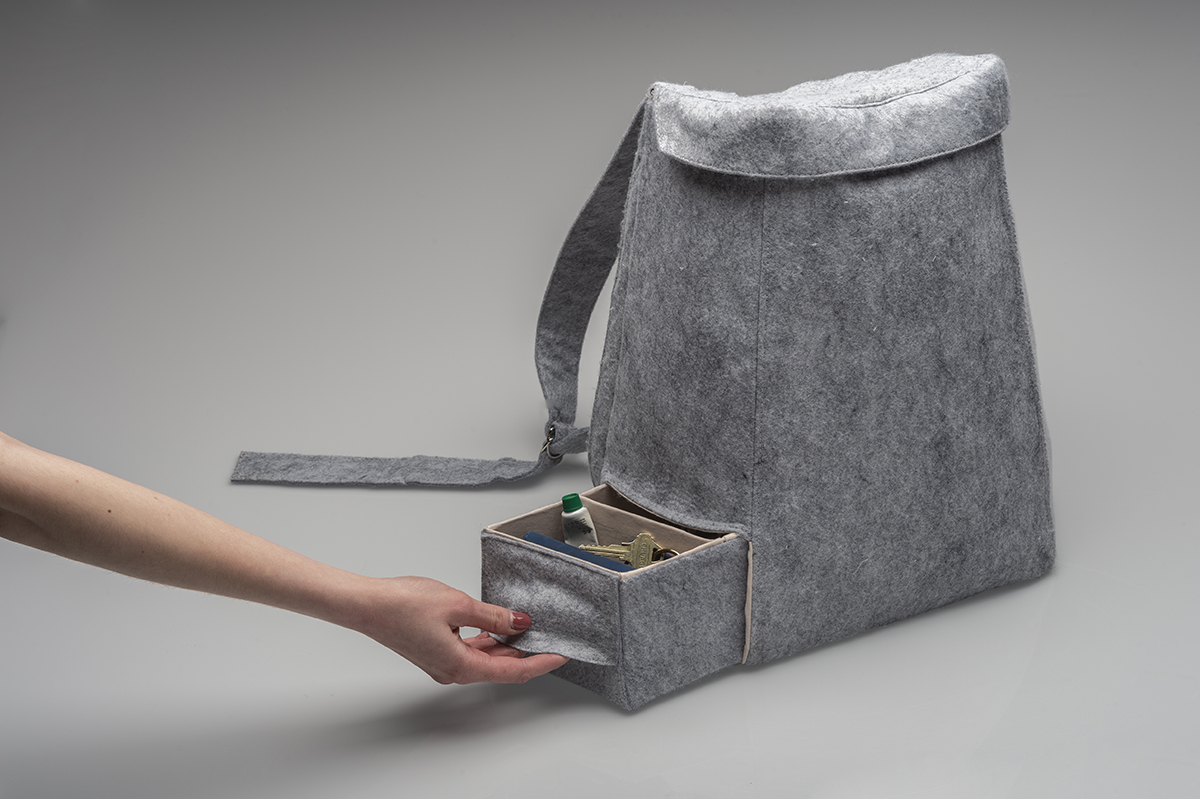 A bag design with a small compartment that pulls out to hold items like keys and lotions. 
