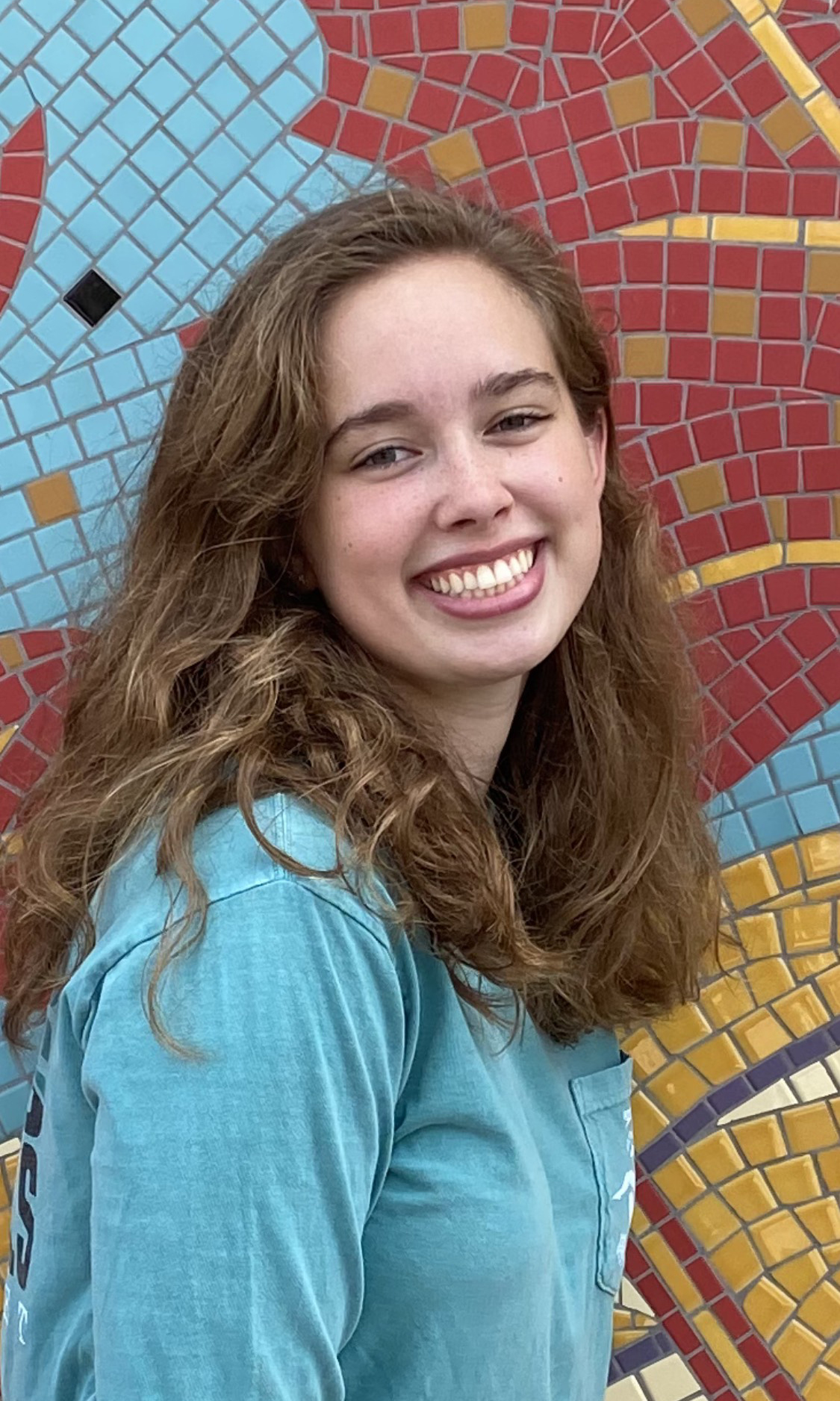 Devon Scott-Davis photographed against a colorful wall.