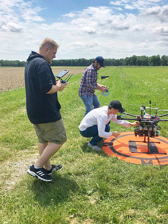 Researchers set up drone in farmers field.