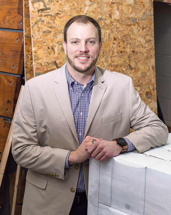 Head-and-shoulders view of man wearing tan suit jacket.