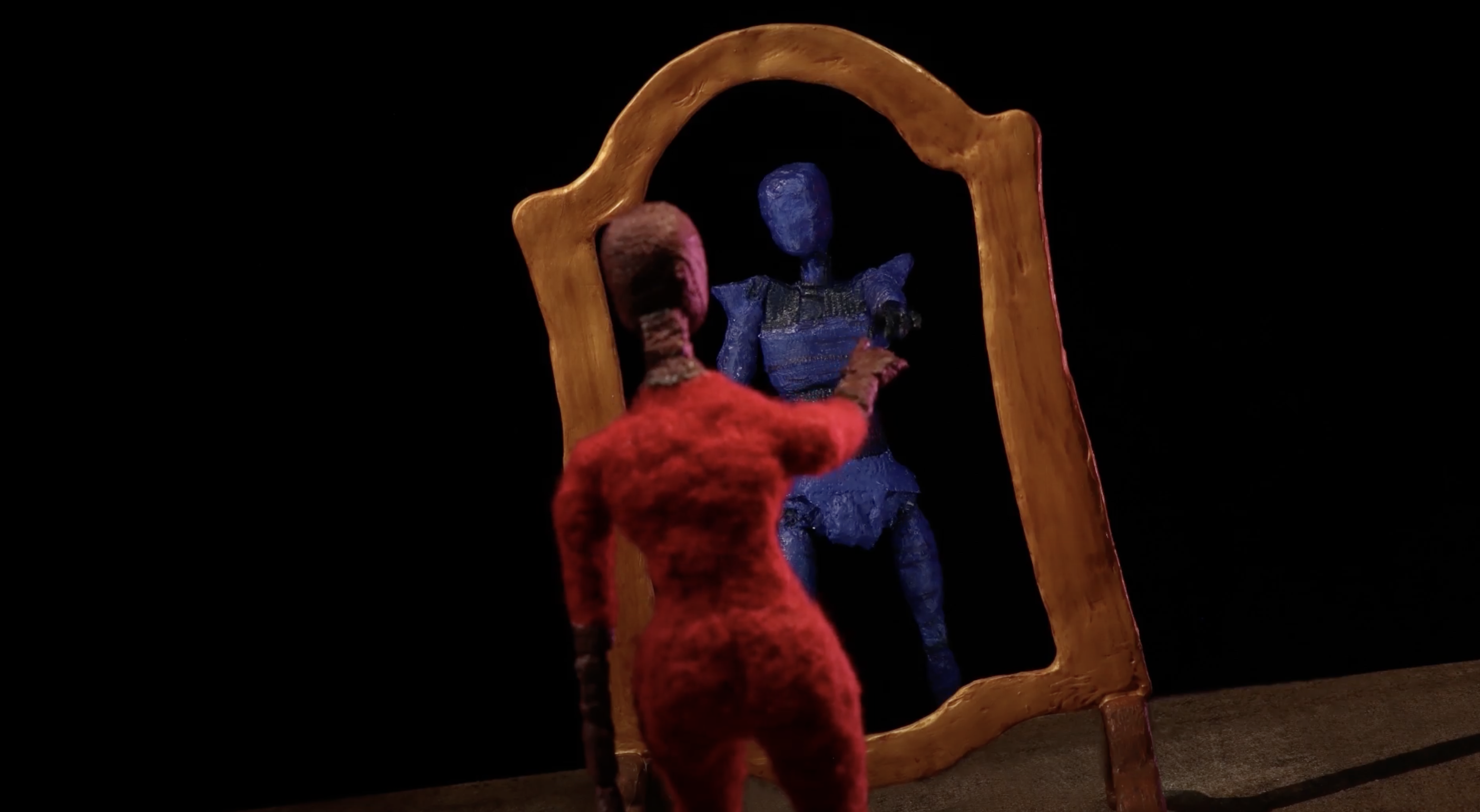 A stop motion character looks into the mirror.