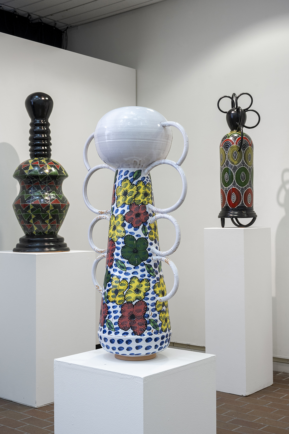 Three tall ceramic vessels on pedestals in Bevier Gallery.