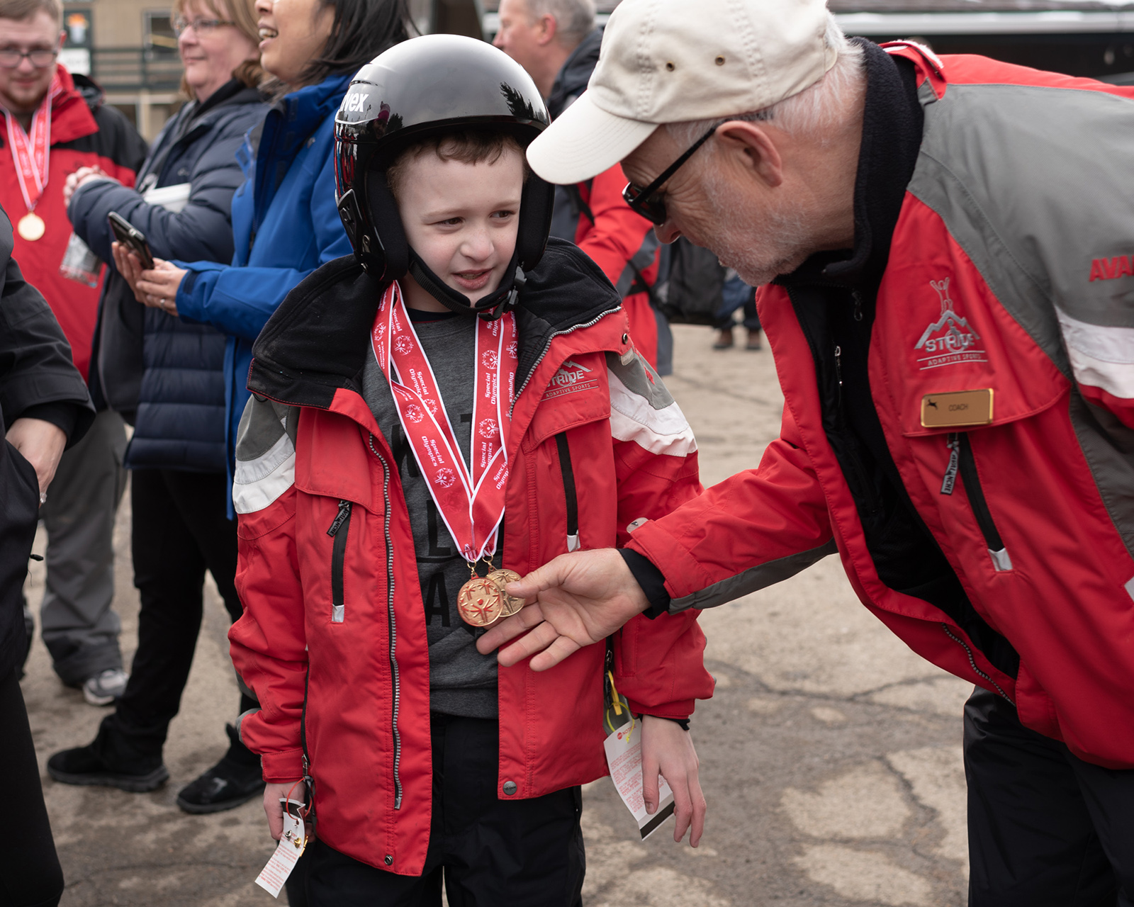 Coach, Marcel Chaine, congratulates Matthew Duffy on his metals for alpine skiing.  