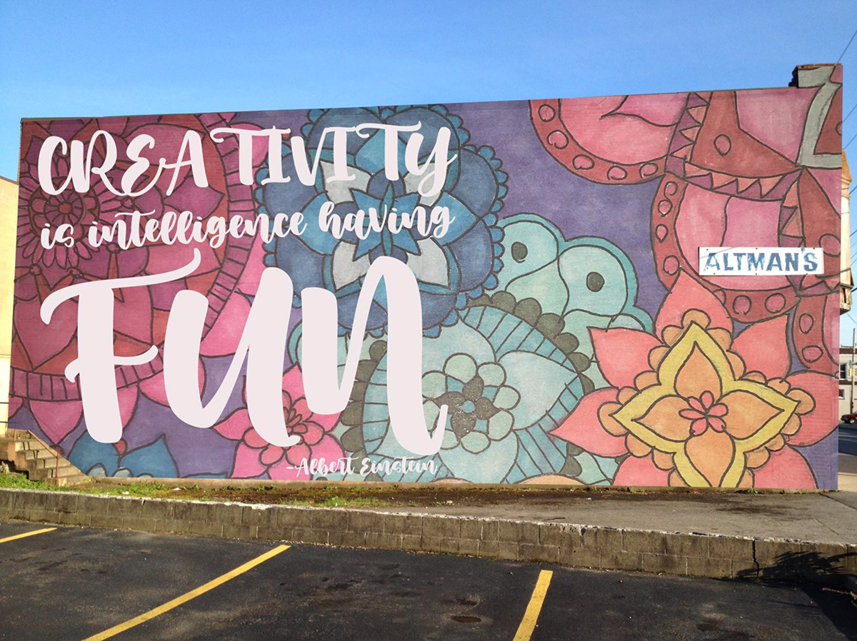 A colorful mural with the words "Creativity is Intelligence Having Fun."