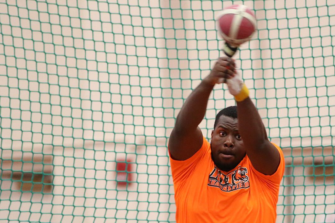 track and field athlete throwing a shot put.