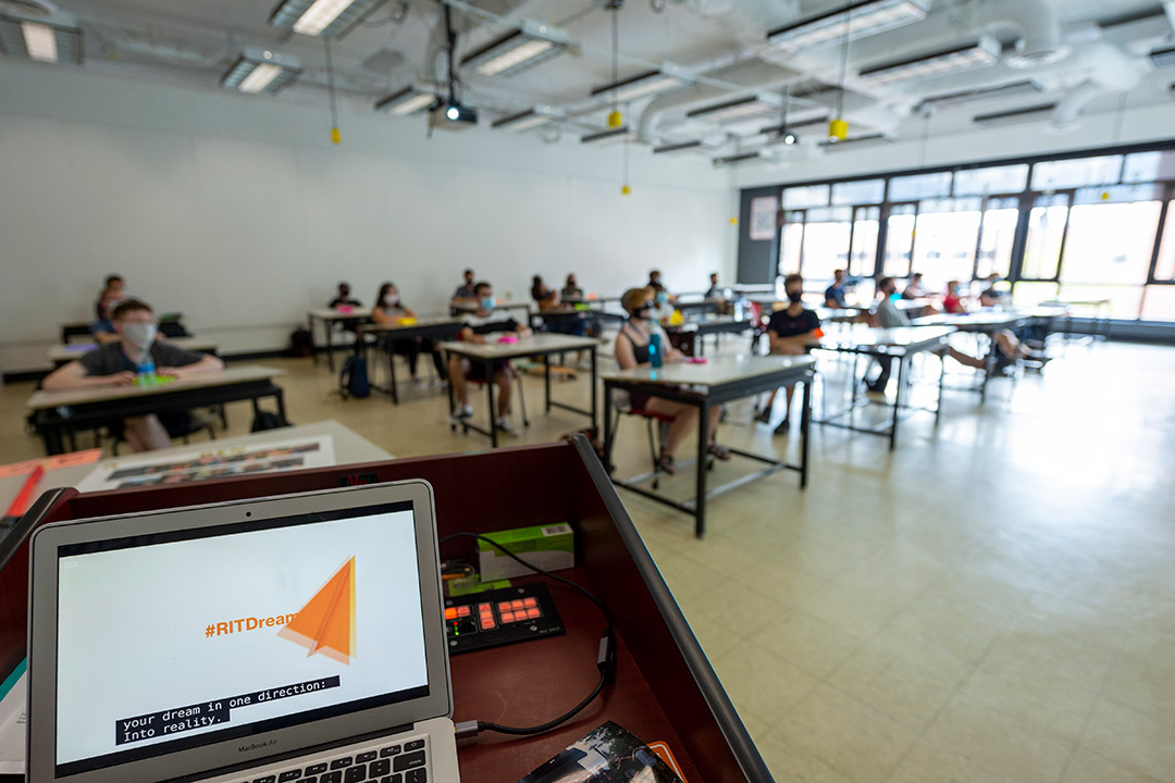 students sitting in a classroom watching a presentation.