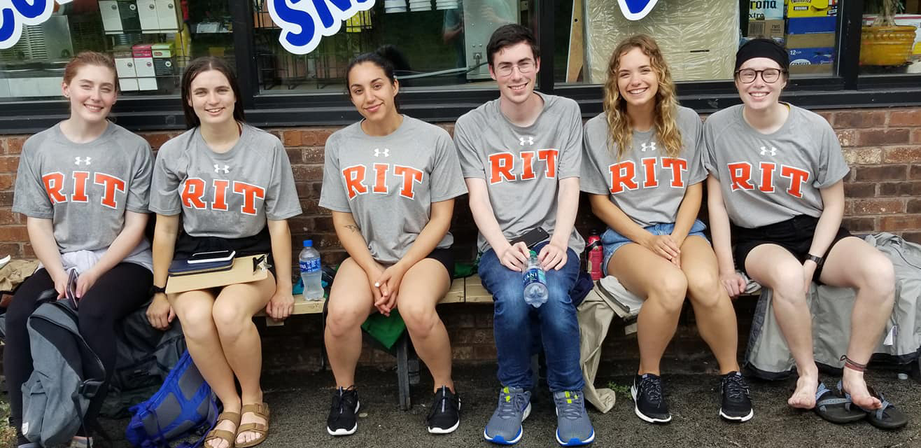 Group of six students sitting on bench.