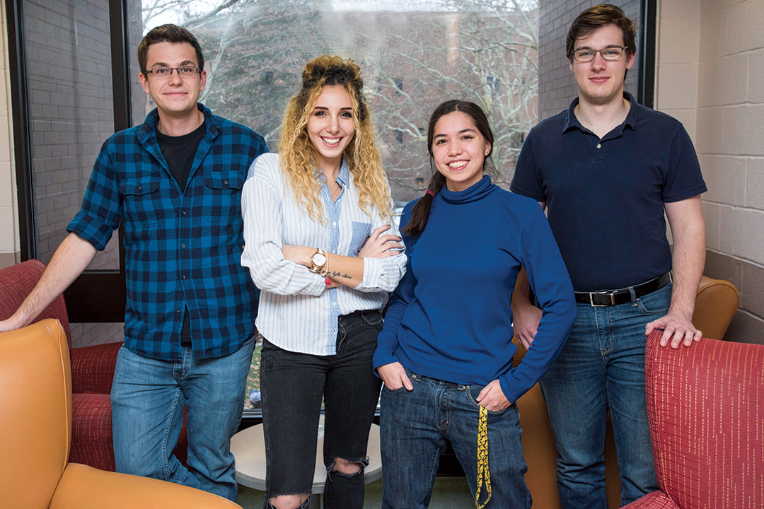 Group of four students stands.