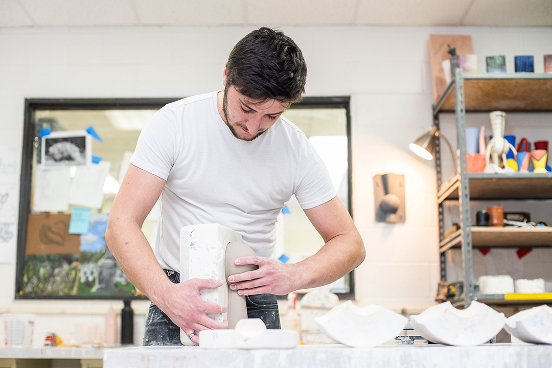 A student manipulating clay object.