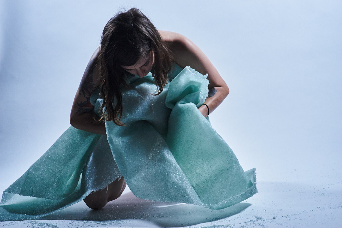 A woman wrapped in a contemporary glass dress.