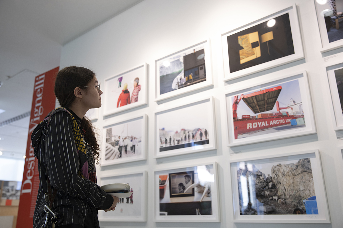 A person looks at a wall display of Denis Defibaugh's Greenland photos. The photo was taken as part of Denis Defibaugh's NSF grant.