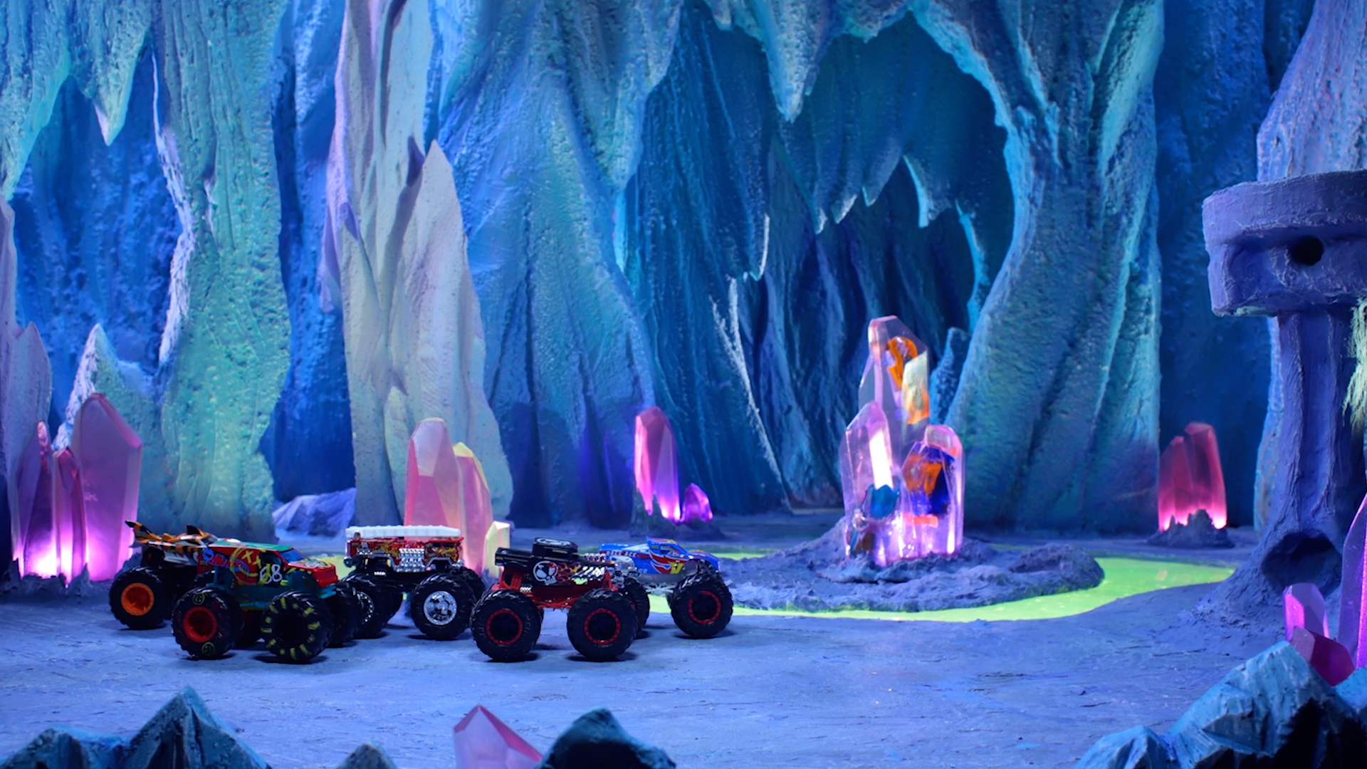 A stop motion scene of hot wheels monster trucks in an igloo.