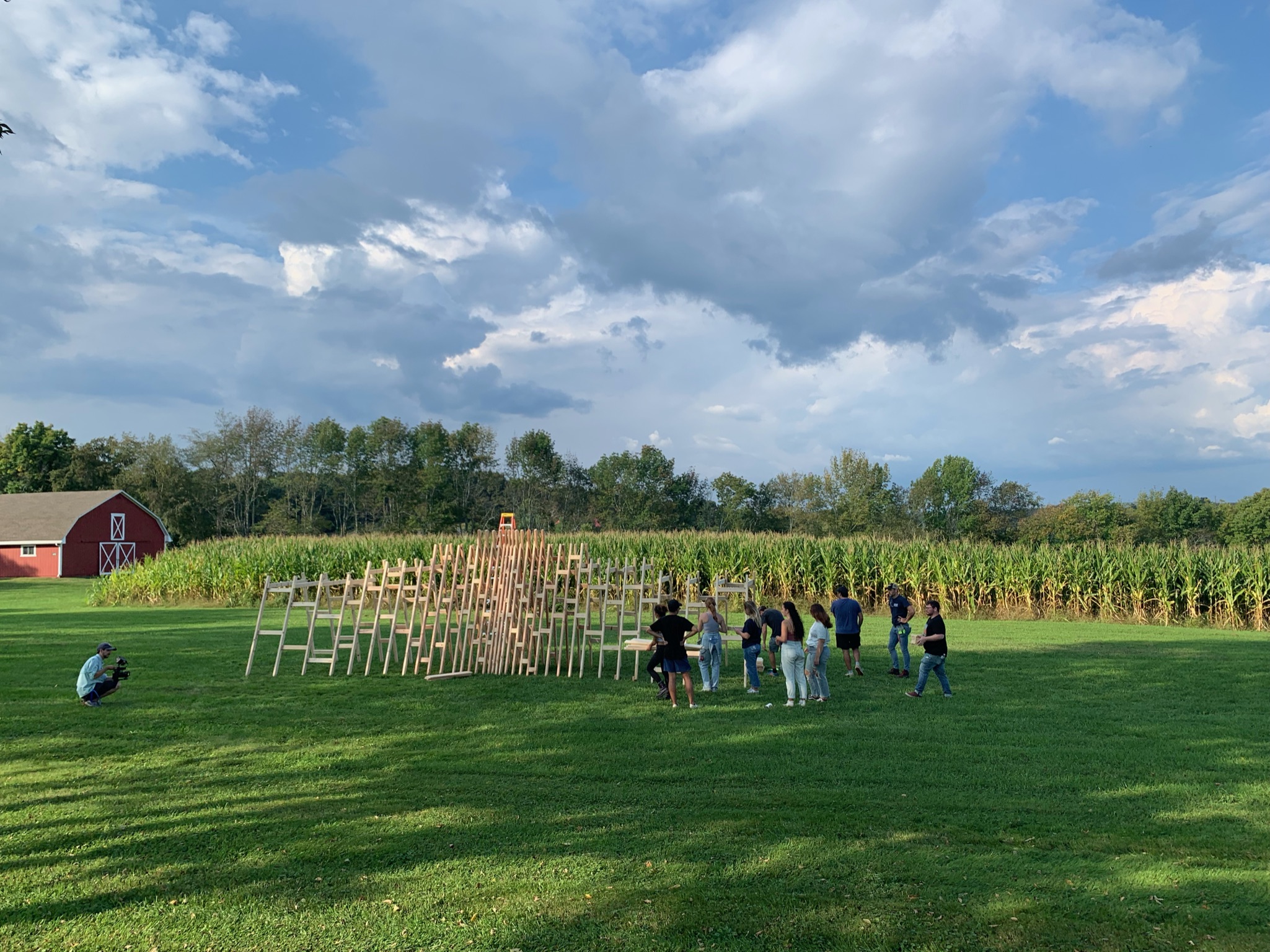 Students collaborate on the construction of a large wooden sculpture.