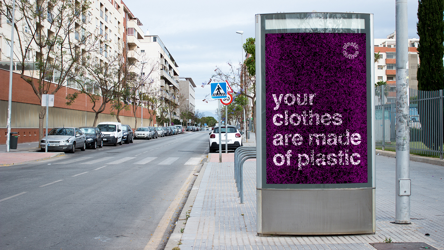 A sign at a bus station that reads Your Clothes Are Made of Plastic.