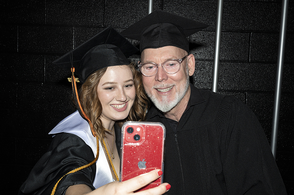 Abby Curtis and David Turner take a selfie in regalia.