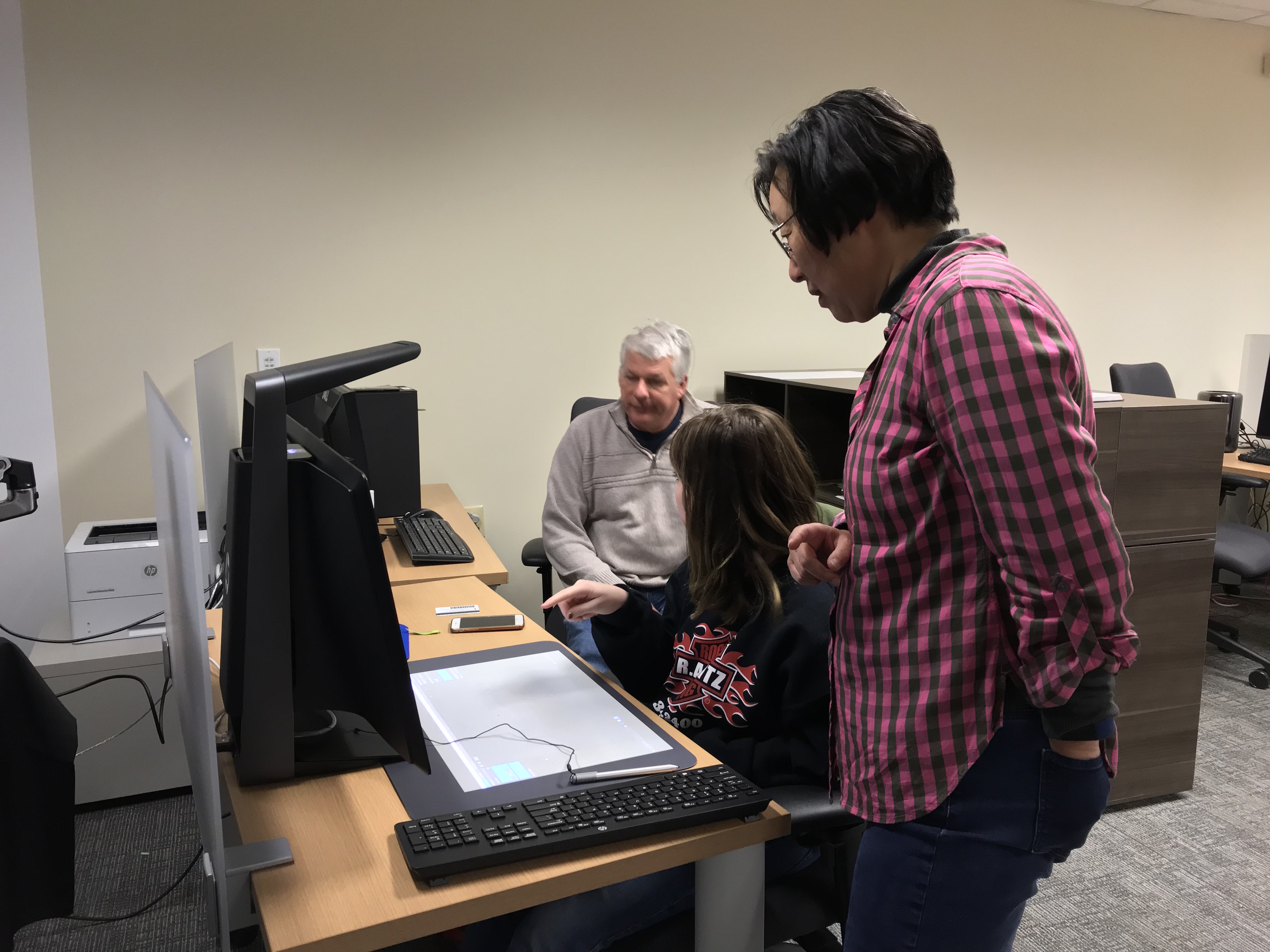 3 people work on a computer