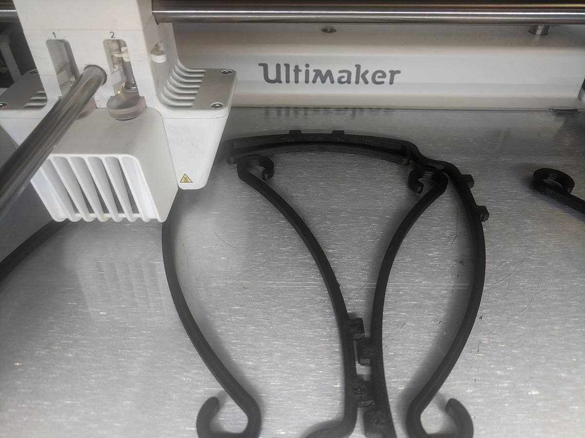 A 3D printer prints a headband for face shields.