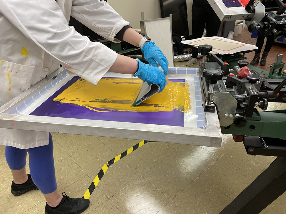 A detailed photo of a student screen printing.