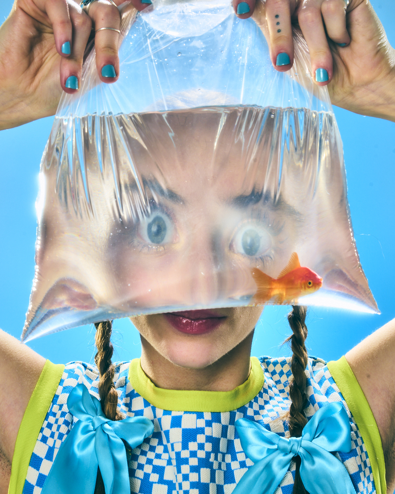 A headshot of Jordyn Katz as she looks through a transparent bag holding a goldfish.