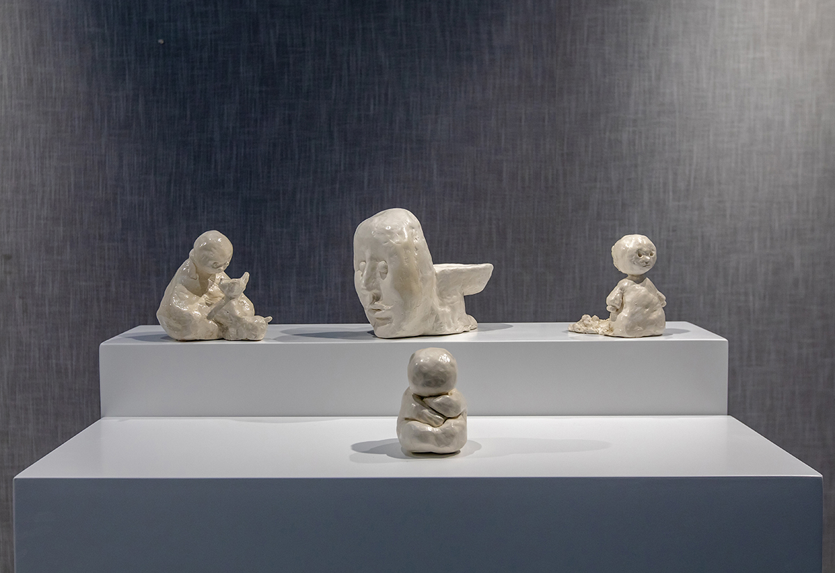 Four ceramic sculptures sit on a surface.