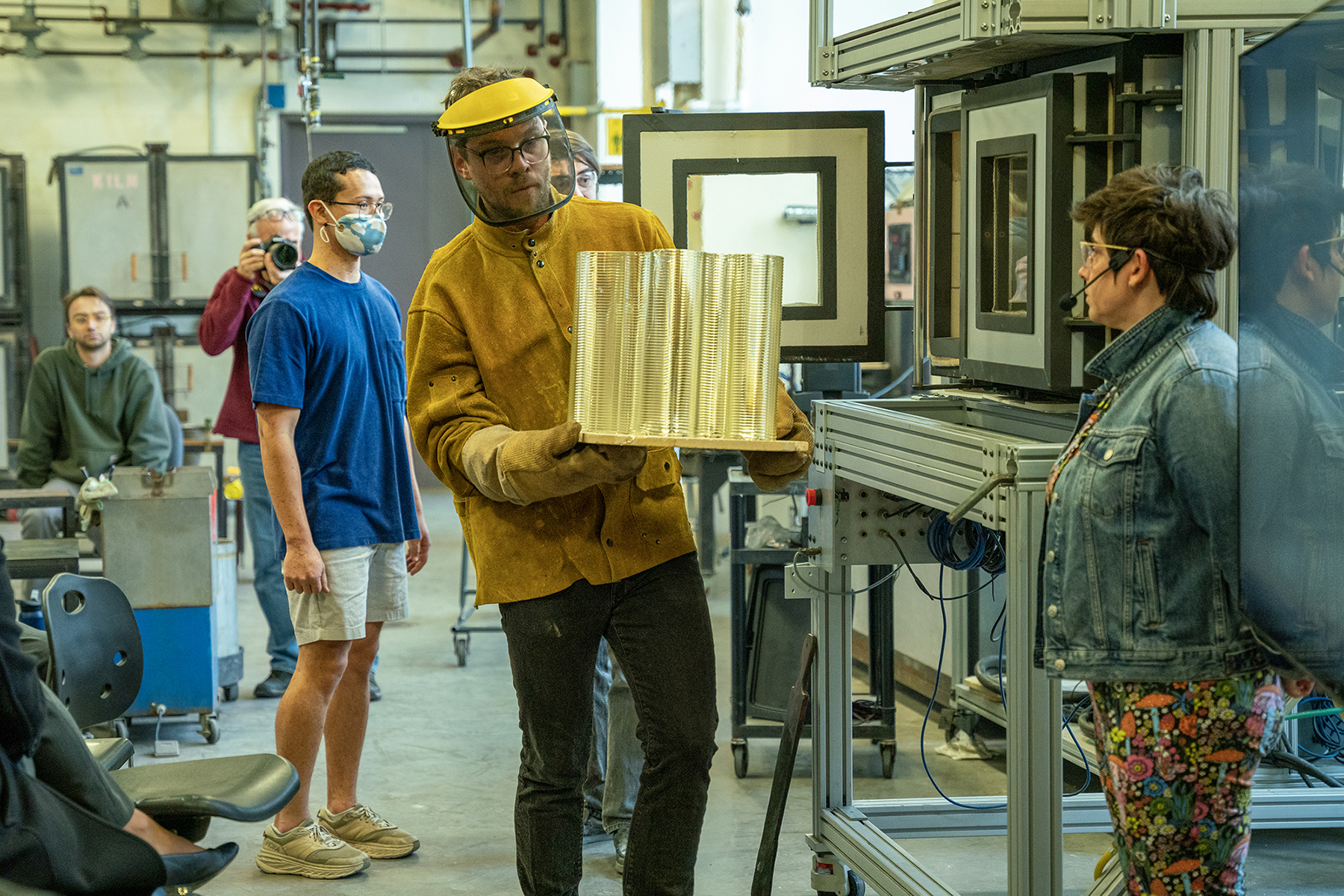 Michael Stern carries a large object he emptied from the molten glass 3D printer.