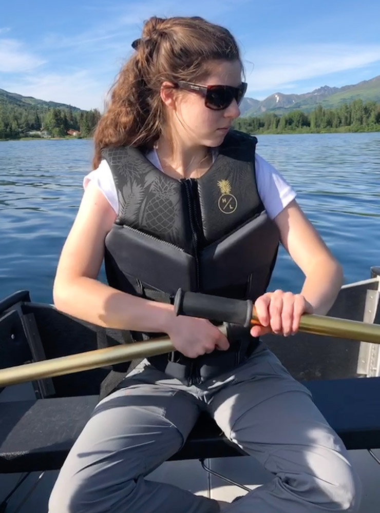 student wearing a life vest in a boat.