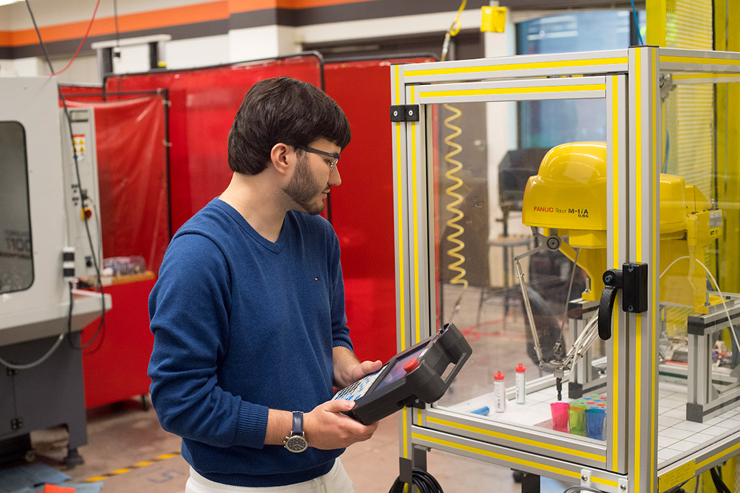 Student uses remote to control a robotic arm.