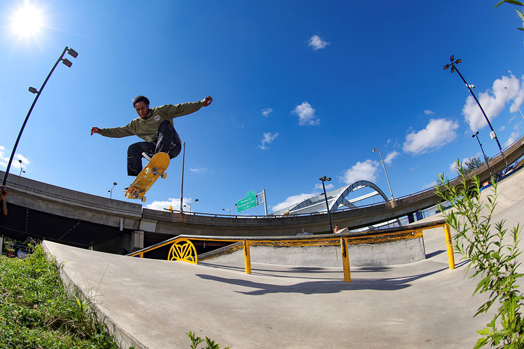 person on a skateboard airborne with his arms outstretched.