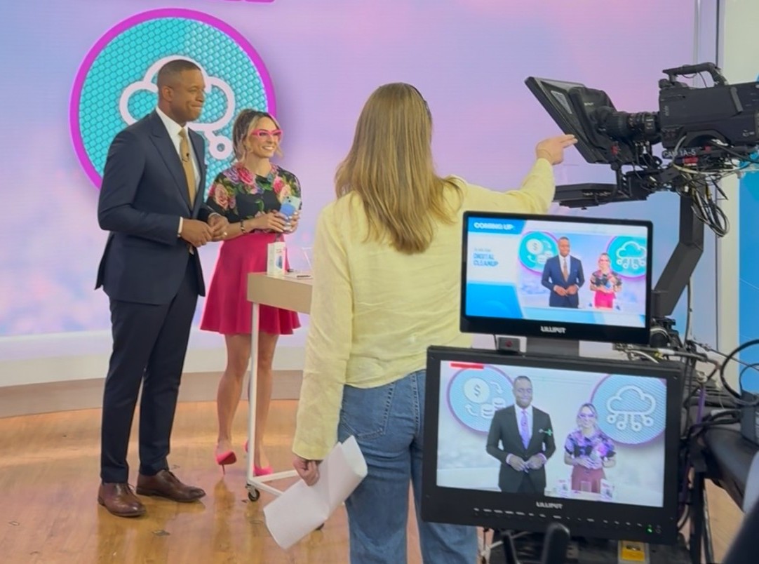 Three people stand on a TV studio set for the Today show. 