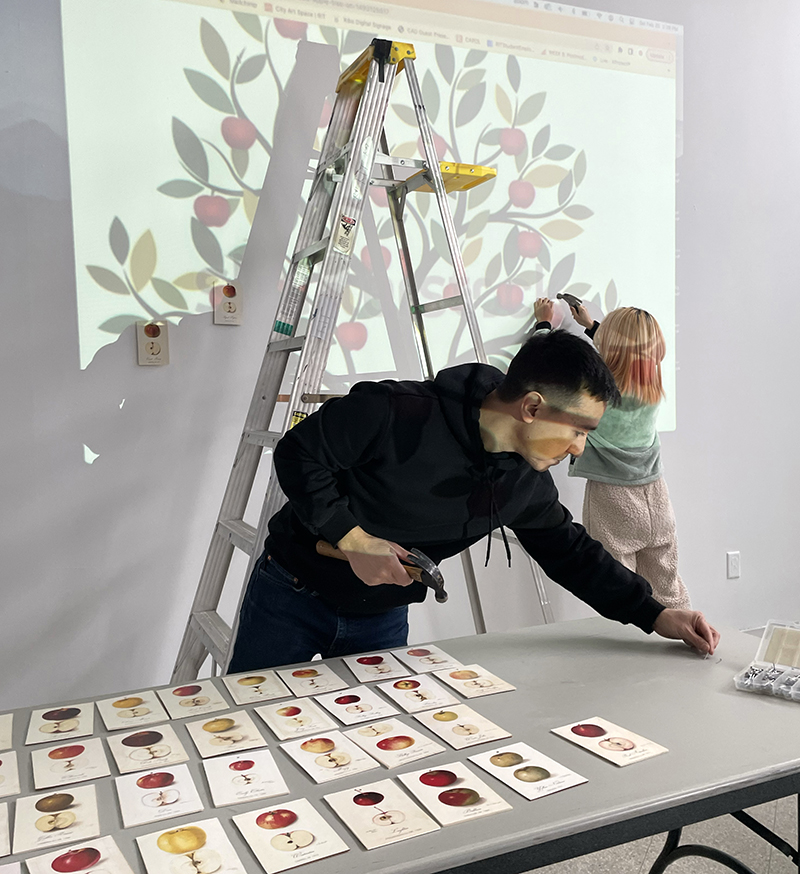 Louis Chavez lays art works on a table at City Art Space.