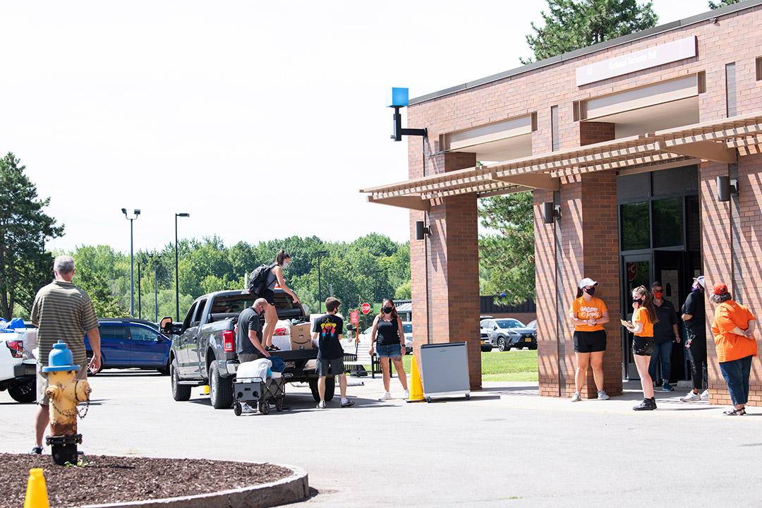 students waiting outside with vehicles to move their belongings into campus housing.